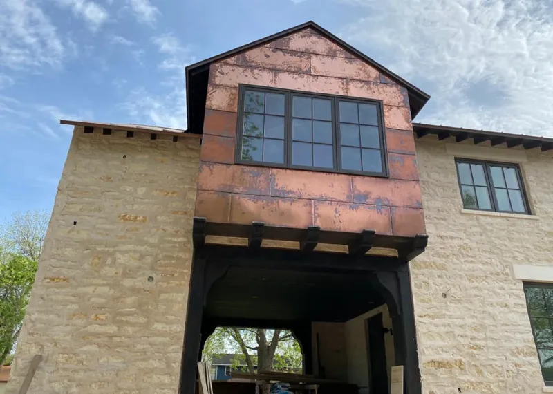 Copper metal panel facade on a stone building for Skylight Installation in Wendell